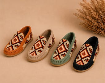 Può includere: Quattro paia di scarpe stile mocassino nei colori arancione, beige, verde e blu navy. Ogni scarpa presenta un motivo geometrico rosso, arancione e bianco. Le scarpe sono in pelle scamosciata e hanno un design casual.