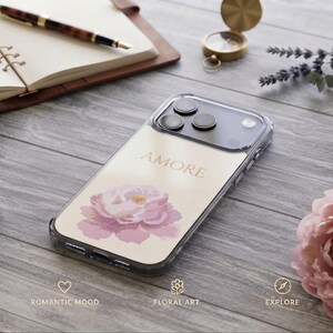 Könnte beinhalten: Eine transparente Smartphone-Hülle mit einem Aufdruck einer zartrosa Pfingstrose und dem Wort AMORE in eleganter Schrift. Die Hülle ist so positioniert, dass die Aussparungen für die Kameralinsen und die transparenten Ränder sichtbar sind.