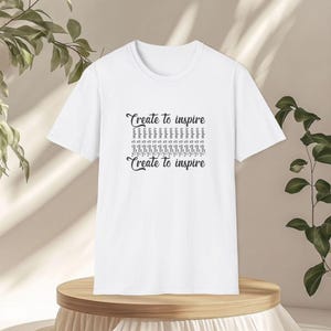 Create to inspire with tower icon on front + "just be" x3 on back. Softstyle 100% ring-spun cotton tee. Breathable, minimalist, ethical.