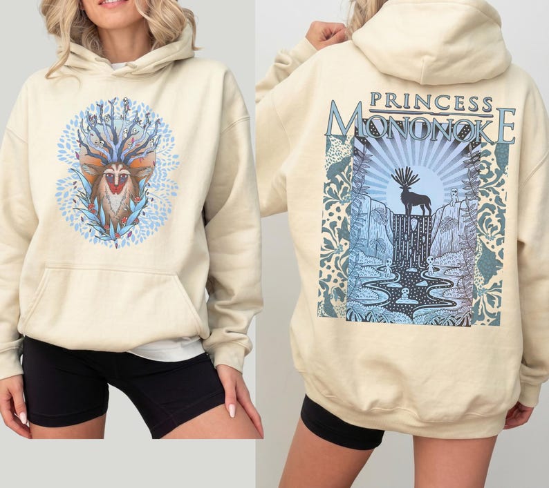 May include: Cream-colored hoodie with a front graphic of a deer-like creature surrounded by blue leaves and a back graphic with the text "PRINCESS MONONOKE" above a deer silhouette and waterfall scene. The hoodie has a front pocket and a hood.