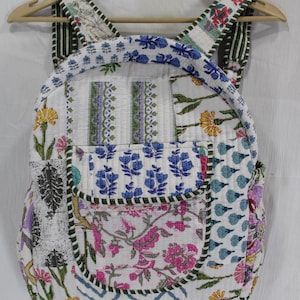 Op de afbeelding: Gewatteerde rugzak met een patchwork ontwerp met bloemen- en geometrische patronen in wit, roze, blauw, groen en geel. De rugzak heeft verstelbare bandjes en een voorvak.