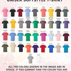 K&ouml;nnte beinhalten: Eine Farbkarte f&uuml;r Unisex-Softstyle-T-Shirts mit einundvierzig verschiedenen Farboptionen, die in Reihen angeordnet sind. Jedes T-Shirt ist mit seinem spezifischen Farbnamen beschriftet, darunter T&ouml;ne wie Azalea, Schwarz, Kardinalrot und Wei&szlig;.