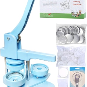 May include: A light blue badge making machine with a vertical handle, a circular press, and a sliding base. Included are a box labeled DCBADGE DC-109, a bag of metal badge components, a bag of white plastic backs, and an adjustable circle cutter tool.