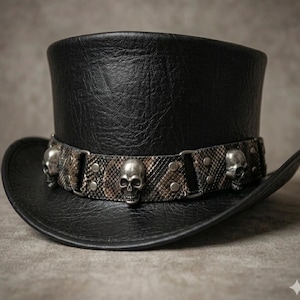 Op de afbeelding: Een zwarte hoge hoed met een getextureerd oppervlak en een decoratieve band. De band is gemaakt van bruin en zwart materiaal met een slangenleerpatroon, versierd met zilverkleurige metalen schedels en kleine ronde metalen klinknagels.