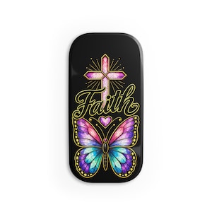 May include: A black rectangular object featuring a stained-glass style graphic of a cross and a butterfly with pink, purple, and blue wings. The word Faith is written in yellow cursive script between the cross and the butterfly, with a small heart.