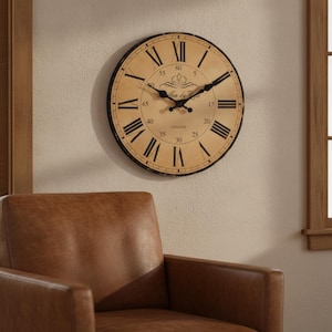 May include: A round wall clock with a beige face, black Roman numerals, and black hands. The clock features a central decorative flourish, the text 'London' at the bottom, and a black outer frame. The design includes minute markers in increments of five.