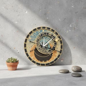May include: A round wall clock featuring a complex astronomical design with a black outer ring displaying zodiac symbols and Roman numerals. The centre includes a smaller rotating dial with gold accents, white clock hands, and a sun icon.