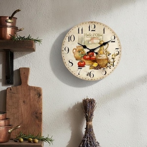Peut inclure: Une horloge murale ronde au cadran crème avec des chiffres arabes noirs et des aiguilles noires. Le centre présente une illustration imprimée d'une cruche en céramique, de tomates rouges et d'une bouteille d'huile d'olive avec le texte Huile d'Olive.