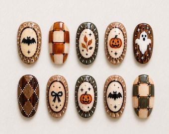 May include: A set of ten oval-shaped press-on nails featuring various designs including a black bat, brown and cream checkered patterns, autumn leaves, orange pumpkins, a white ghost, a brown argyle print, and a black bow on a cream background.