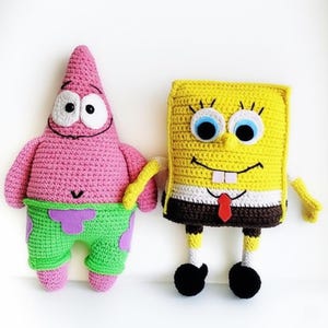 May include: Crocheted figures of Patrick Star and SpongeBob SquarePants. Patrick is pink with green shorts and purple accents. SpongeBob is yellow with a white shirt, brown pants, and a red tie. Both have black eyes and smiles.