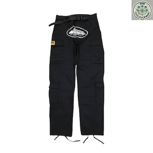 May include: Black cargo pants with multiple pockets, a black belt, and a white and black graphic on the front. The pants have drawstrings at the ankles and a small yellow patch. The pants are displayed on a white background.