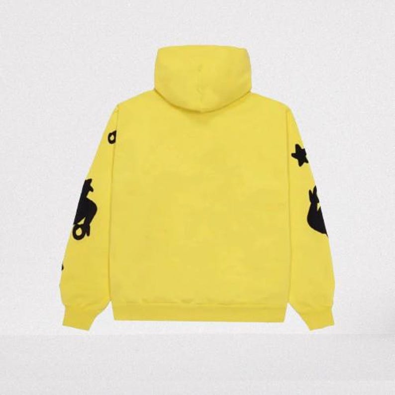 May include: A bright yellow hoodie with a hood and long sleeves. The sleeves feature black graphic designs. The hoodie is made of a soft material and has a ribbed hem and cuffs. The background is a solid, neutral color.