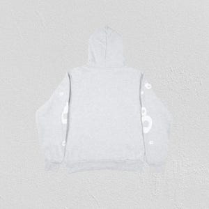 May include: A light gray hoodie with a hood and long sleeves. White lettering is visible on the sleeves. The hoodie is made of a soft material and is suitable for casual wear.