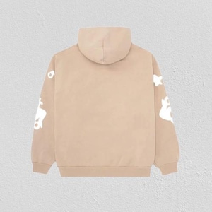 May include: A tan hoodie with a hood and long sleeves. White graphic designs are printed on the sleeves. The hoodie is made of a soft material and is suitable for casual wear.