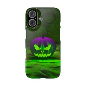 Puede incluir: Una funda de teléfono con temática de Halloween. La funda tiene un fondo verde con una calabaza morada con una cara verde brillante. La calabaza está en el centro de la funda.