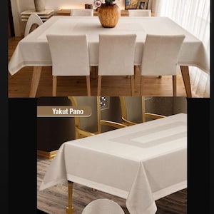 May include: Beige rectangular tablecloth with a lighter beige border, displayed on a wooden table with matching chairs. The image also shows a close-up of the tablecloth's texture and dimensions.