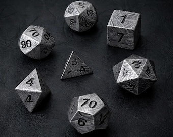 Pode incluir: Um conjunto de sete dados poliédricos com acabamento em metal prateado, um padrão escuro e ondulado estilo damasco e números gravados em preto. A coleção inclui um d20, d12, d10, d8, d6, d4 e um dado de percentagem, dispostos em círculo.