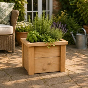 May include: A rectangular wooden planter box, filled with a variety of herbs and lavender. The light-coloured wood planter contains green herbs and purple lavender. The planter is placed on a stone patio, with a wicker chair and other potted plants in the background.