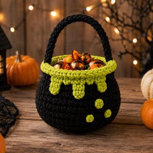 May include: A black crocheted basket shaped like a cauldron with a lime green rim featuring a dripping liquid design and three small lime green circles on the side. The basket has a thick black handle and is filled with various wrapped sweets.