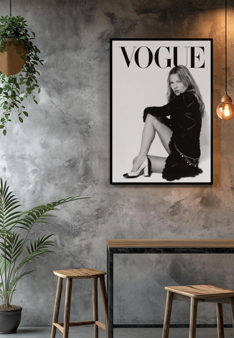 Puede incluir: Impresi&oacute;n en blanco y negro de una portada de la revista Vogue con una mujer con un vestido negro y tacones. El logo de Vogue est&aacute; en la parte superior. La impresi&oacute;n est&aacute; en un marco negro, exhibida en una pared gris texturizada con taburetes y una mesa de madera.