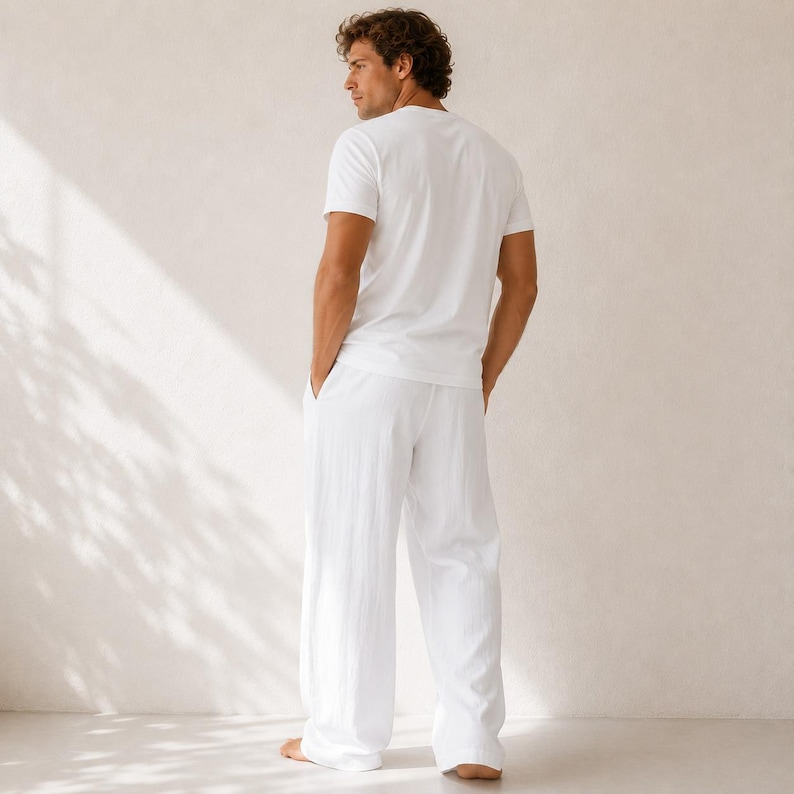 May include: A solid white short-sleeved t-shirt paired with matching white long trousers. The outfit features a clean, plain design with a standard crew neckline and a relaxed fit, showcasing a simple and uniform monochromatic white color scheme.