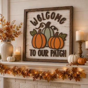 May include: A square wooden sign with a dark brown frame and white shiplap background. It features the text WELCOME TO OUR PATCH in dark brown letters, centered above and below three dimensional pumpkins in orange and sage green colors.