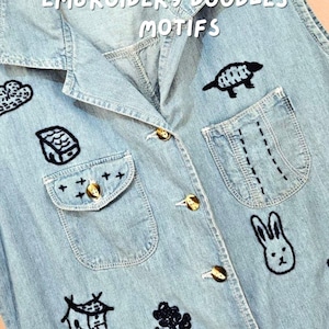 Peut inclure: Une chemise sans manches en jean bleu clair ornée de broderies bleu foncé représentant divers motifs, dont un lapin, une maison et une tortue. La chemise possède un col, des boutons dorés et deux poches avant avec des détails cousus.