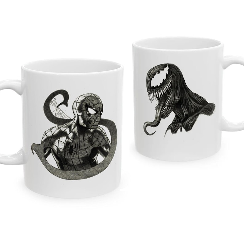 Puede incluir: Dos tazas de cer&aacute;mica blanca con ilustraciones detalladas en blanco y negro. Una taza muestra una figura de superh&eacute;roe enmascarado con un patr&oacute;n de telara&ntilde;a, mientras que la otra muestra una criatura con dientes afilados, una lengua larga y un ojo blanco grande.