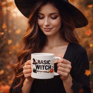 May include: A white ceramic mug featuring the text "BASIC WITCH" in black letters, accompanied by colorful illustrations of a witch hat, a green bubbling cauldron, a broomstick, a small ghost, and a jack-o'-lantern pumpkin on the front surface.