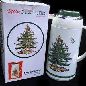 May include: White thermal carafe with a green lid and a Christmas tree design. The carafe is in its original box, which also features a Christmas tree design and the text "Spode Christmas Tree Thermal Carafe".
