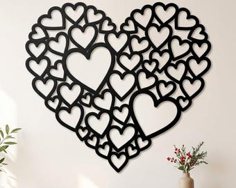 Puede incluir: Una gran decoración de pared negra con forma de corazón, compuesta por una red compleja e interconectada de muchos contornos de corazones más pequeños de varios tamaños. El diseño presenta un patrón denso y calado.