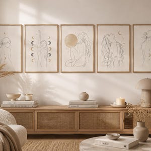 Peut inclure: Cinq impressions d'art encadrées avec des dessins au trait de figures, de lunes et de soleils. L'art est dans des tons neutres, avec un fond beige et des cadres bruns fins. L'œuvre est exposée au-dessus d'un meuble en bois avec des objets décoratifs.