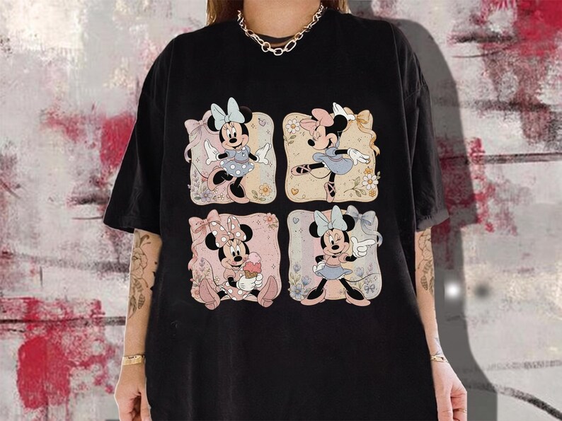 May include: Black t-shirt featuring four panels with Minnie Mouse illustrations. Each panel showcases Minnie in different poses, wearing dresses and bows. The background of each panel has floral and pastel elements.