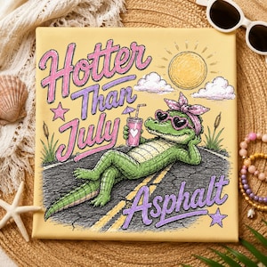 May include: A square canvas print with a yellow background features a cartoon alligator wearing heart-shaped sunglasses and a pink headband, lounging on a road. The text "Hotter Than July Asphalt" is written in pink and purple. A sun, clouds, and a drink are also depicted.