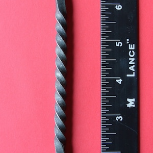 Peut inclure: Un ouvre-bouteille en métal torsadé avec deux boucles à chaque extrémité. L'ouvre-bouteille mesure environ 18 cm de long et est mesuré à l'aide d'une règle.