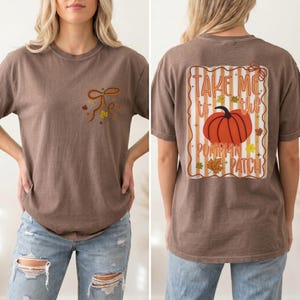 May include: A brown short-sleeve t-shirt featuring a small orange ribbon graphic on the front left chest. The back displays a large rectangular graphic with orange stripes, a pumpkin illustration, and the text Take me to the pumpkin patch.