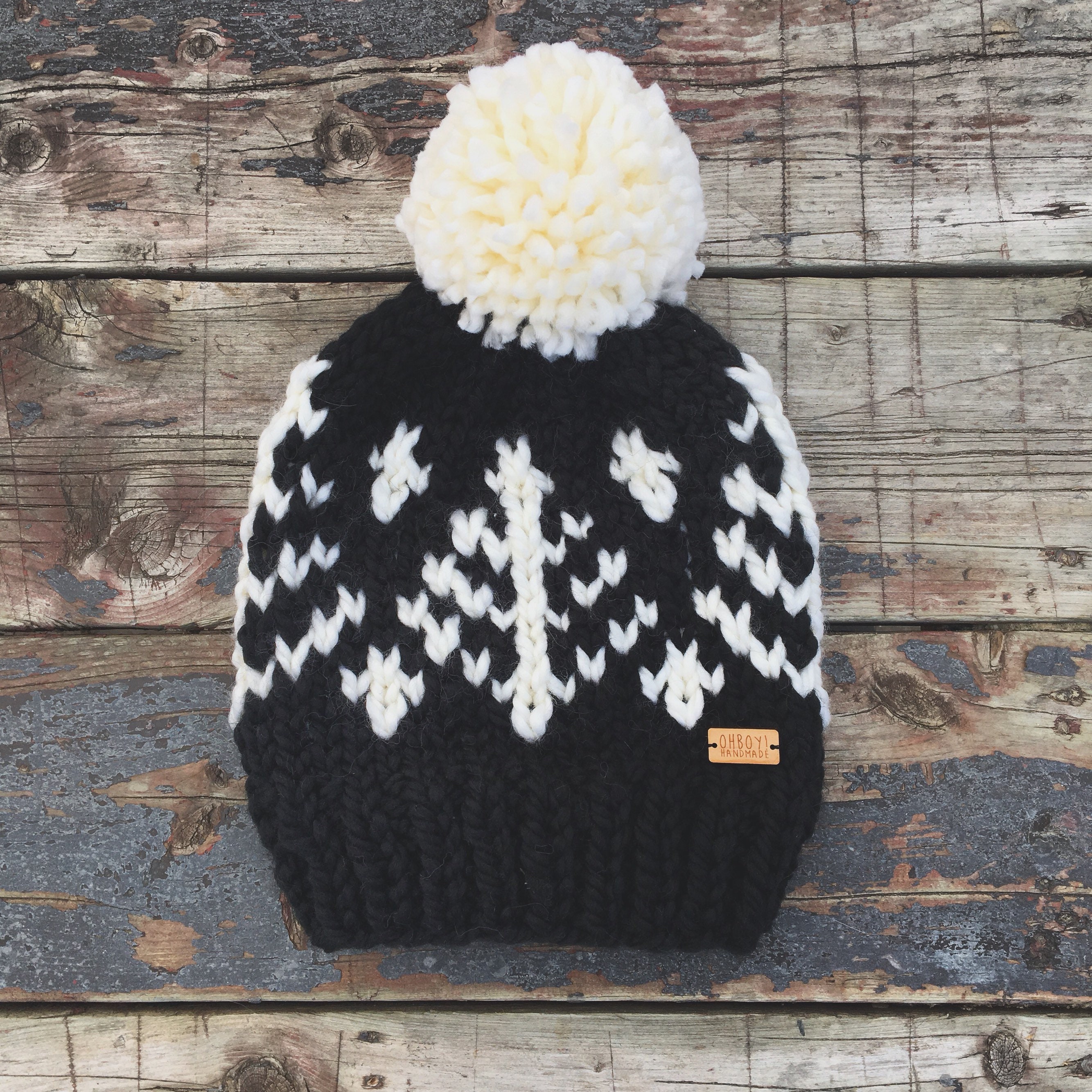 black hat with cream pom pom
