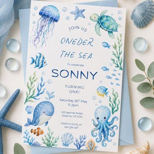 May include: A white rectangular invitation card featuring watercolor illustrations of a jellyfish, sea turtle, whale, octopus, and various fish. The text reads: JOIN US ONEDER THE SEA To celebrate SONNY TURNING ONE! Saturday 26th May 11-2pm.