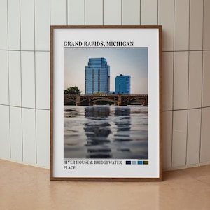 May include: A framed wall art print featuring a photograph of the Grand Rapids, Michigan skyline with the River House and Bridgewater Place buildings, a bridge over water, and a color palette strip at the bottom with the text labels included.