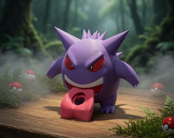 Puede incluir: Figura morada de Gengar con ojos rojos y lengua rosa, sobre una superficie de madera. Varias Poké Balls rojas y blancas dispersas, con fondo de bosque. Es un artículo de colección.