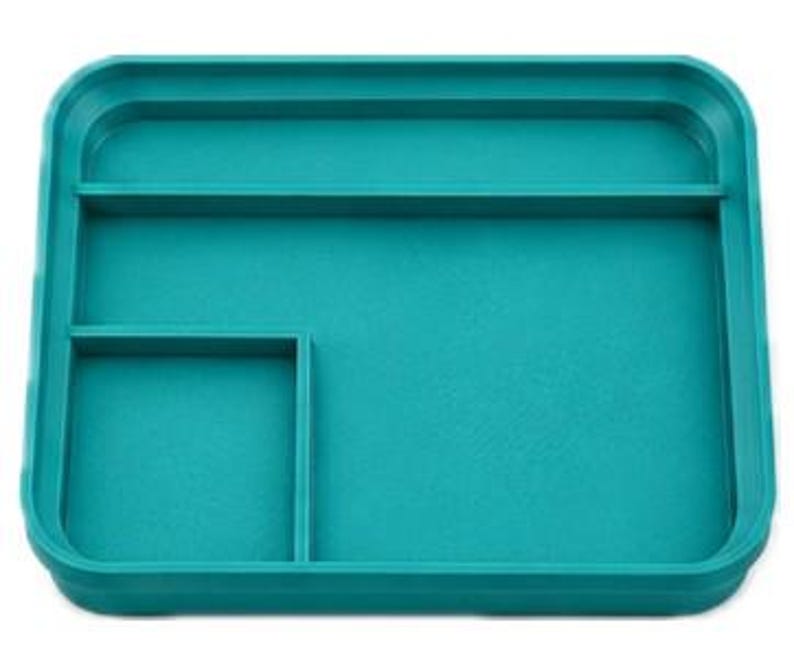 Op de afbeelding: Een teal rechthoekige tray met opstaande randen en drie compartimenten. De tray heeft een groot open gedeelte en twee kleinere, rechthoekige secties. Afmetingen: ongeveer 20 cm bij 15 cm.