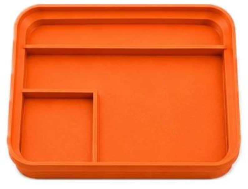 Op de afbeelding: Een oranje rechthoekige lade met afgeronde hoeken en opstaande randen. De lade is verdeeld in drie secties: een groot open gedeelte, een rechthoekig compartiment en een kleiner vierkant compartiment. De lade is gemaakt van een solide, ondoorzichtig materiaal.