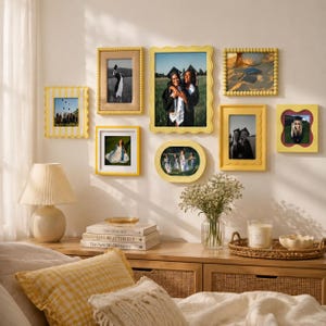 Peut inclure: Un ensemble de sept cadres photo jaunes de formes et tailles variées, incluant des modèles rectangulaires, ovales et festonnés, affichant des photographies de remise de diplôme, fixés sur un mur uni au-dessus d'une console en bois.