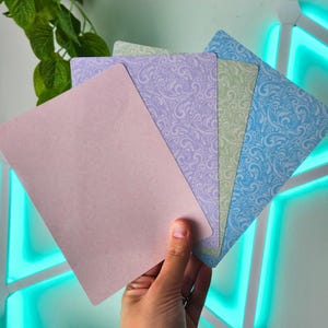 May include: A set of four rectangular cards featuring a pastel color palette. The cards display a solid light pink, a lavender damask pattern, a light green damask pattern, and a bright blue damask pattern, all with rounded corners.