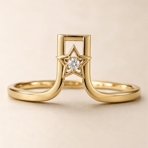 Peut inclure: Une bague en or présentant un design en arche surélevée avec un motif central en forme d'étoile à cinq branches. L'étoile est sertie d'une pierre précieuse transparente et ronde en son centre. L'anneau a une finition polie et lisse.