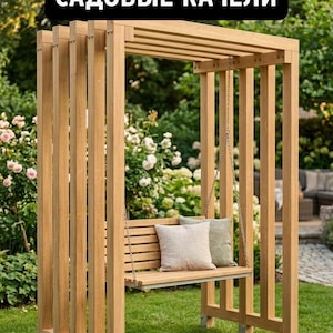 May include: A light brown wooden garden swing set featuring a slatted bench seat suspended by metal chains from a rectangular pergola-style frame. Two square throw pillows rest on the seat. The text "САДОВЫЕ КАЧЕЛИ" is displayed at the top.