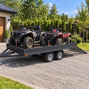 Op de afbeelding: Een donkergrijze aanhangwagen met dubbele as en een vlakke laadvloer, voorzien van een achterklep als laadklep en zijwanden. Twee terreinvoertuigen, één zwart en één rood, staan vast op de laadvloer en zijn uitgerust met lieren aan de voorzijde.
