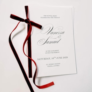 Może przedstawiać: Biała broszura z programem ślubnym przewiązana ciemnoczerwoną aksamitną wstążką. Tekst brzmi: THE NUPTIAL MASS CELEBRATING THE UNION OF Vanessa & Samuel IN THE SACRAMENT OF HOLY MATRIMONY SATURDAY, 16TH JUNE 2028 ST. PETER'S CHURCH VIENNA, AUSTRIA.