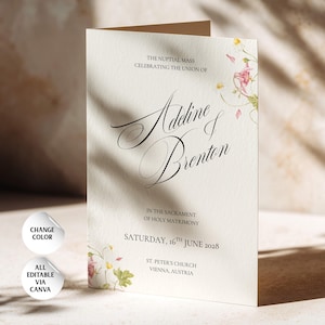 May include: A folded cream-colored wedding program featuring floral illustrations and black text that reads: The Nuptial Mass celebrating the union of Adeline & Brenton in the Sacrament of Holy Matrimony, Saturday, 16th June 2028, St. Peter's Church, Vienna, Austria.