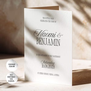 May include: A white folded wedding programme card with black text reading The Nuptial Mass Celebrating the Union of Naomi & Benjamin in the Sacrament of Holy Matrimony, Saturday, 16.06.2028, St. Peter's Church, Vienna, Austria. Two circular icons are present.